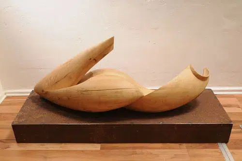 Die Skulptur besteht aus zwei Massiv - Holzteilen, der Sockel aus unbehandeltem Stahl