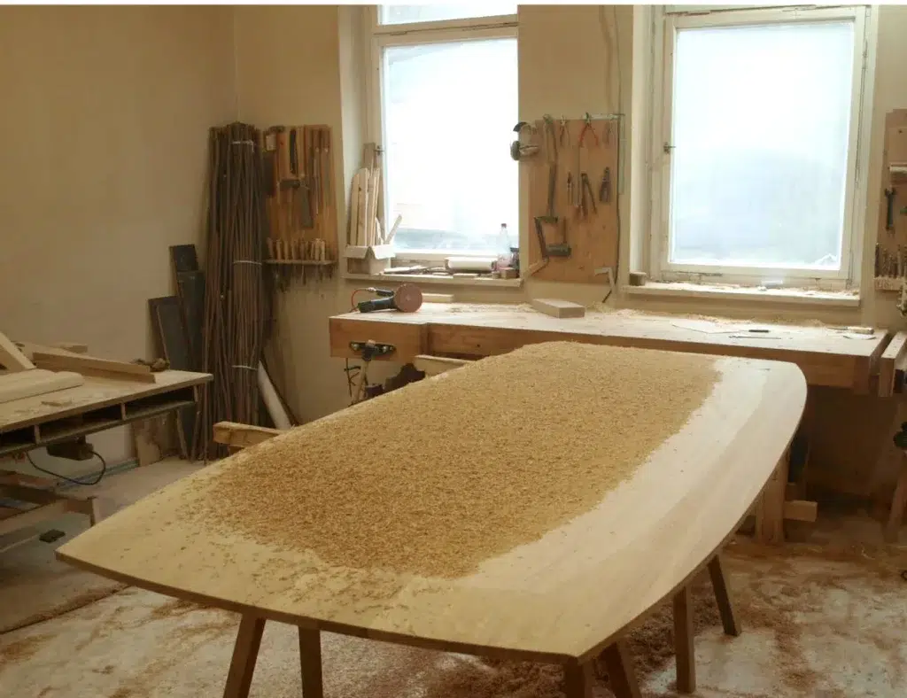 Die Tischplatte aus Holz, von unten, während der Bearbeitung der schmal zulaufenen Seiten